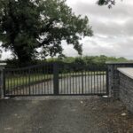 Grey modern style gate - strong vertical bars, grey stonework