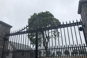 Large entrance gates at stud farm - main gates - black steel very ornate. Arrows and swirls decorating.