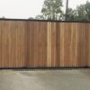 Steel framed automatic gates with solid iroka timber infill