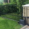 black galvanised and powder coated gate with sliding FAAC automation - shows the sliding rail and automation unit - gate open - decorated with arrows