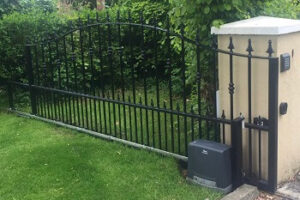 black galvanised and powder coated gate with sliding FAAC automation - shows the sliding rail and automation unit - gate open - decorated with arrows